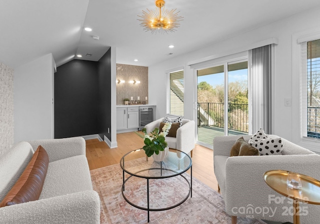 living room with beverage cooler, a dry bar, light wood finished floors, and vaulted ceiling