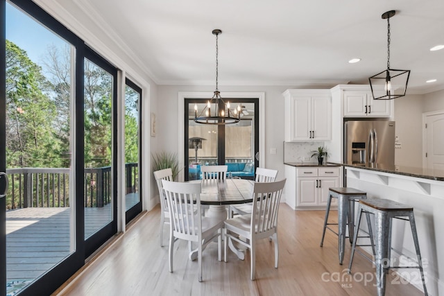 dining space with ornamental molding, an inviting chandelier, recessed lighting, and light wood-style floors