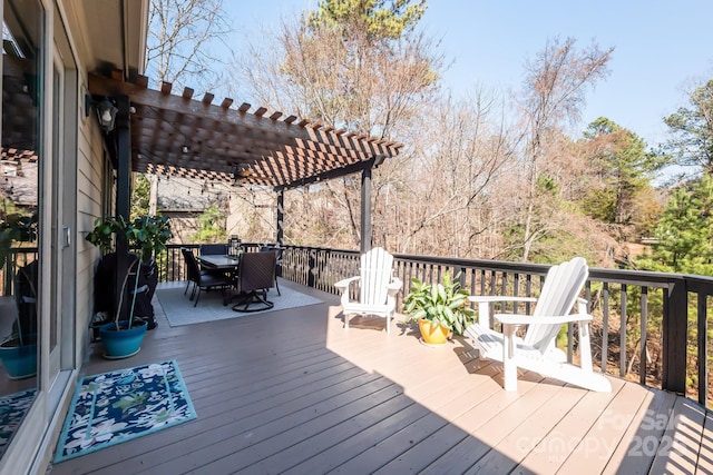 wooden deck featuring a pergola and outdoor dining space