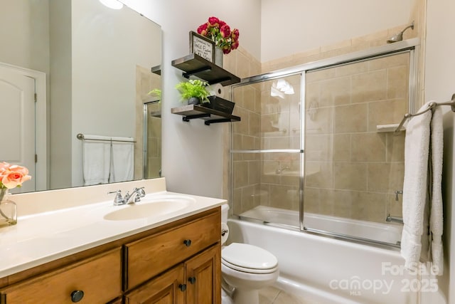 bathroom with combined bath / shower with glass door, vanity, and toilet