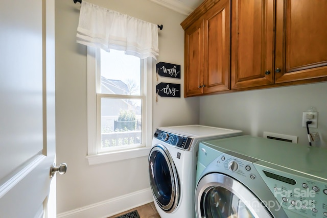 washroom with cabinet space, baseboards, and independent washer and dryer