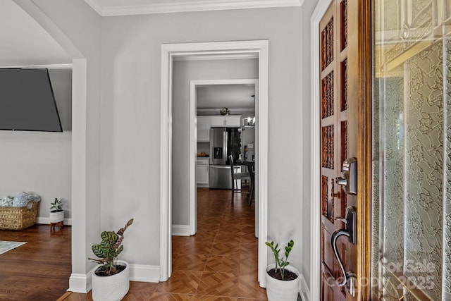 hall featuring baseboards and crown molding