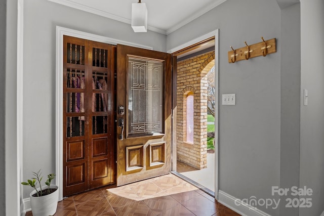 foyer entrance featuring crown molding and baseboards