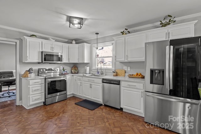 kitchen with a sink, stainless steel appliances, ornamental molding, and light countertops