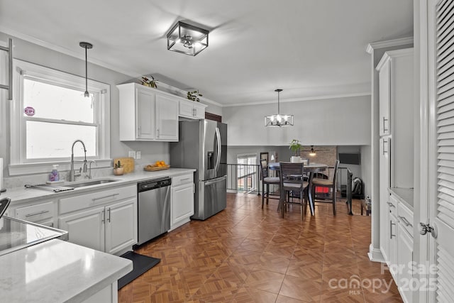 kitchen with light countertops, white cabinets, appliances with stainless steel finishes, and a sink