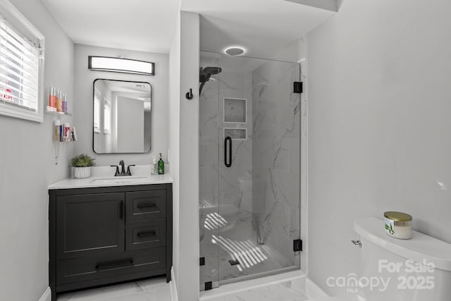 full bathroom featuring a marble finish shower, marble finish floor, toilet, and vanity