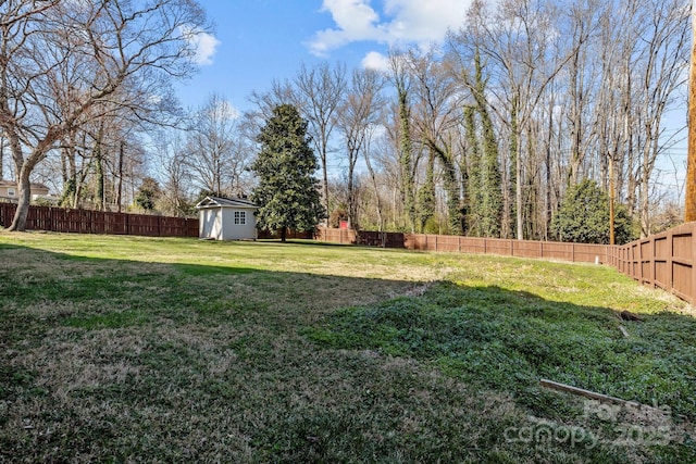 view of yard with a fenced backyard, a shed, and an outdoor structure