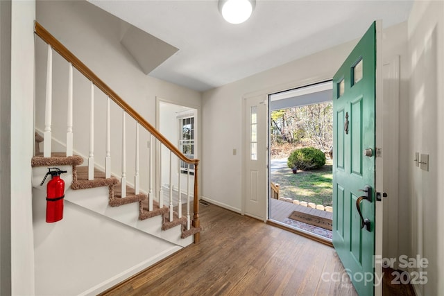 entrance foyer featuring stairs, baseboards, and wood finished floors