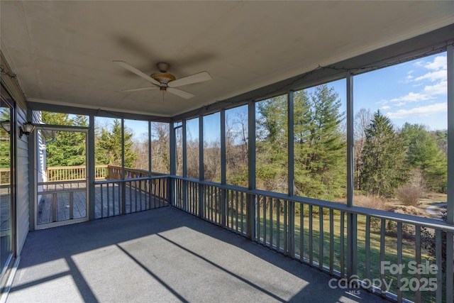 unfurnished sunroom with ceiling fan