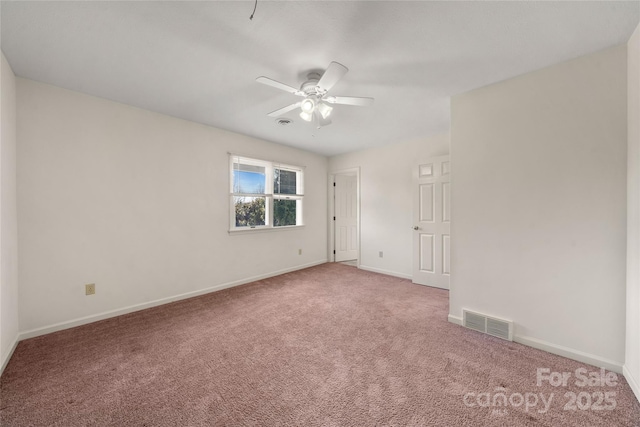 carpeted empty room with a ceiling fan, visible vents, and baseboards