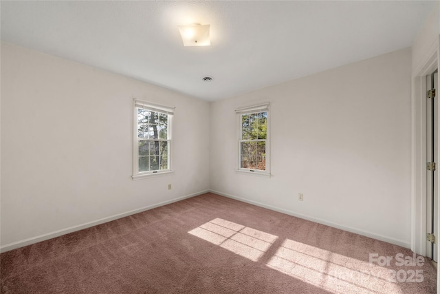 spare room with carpet and baseboards