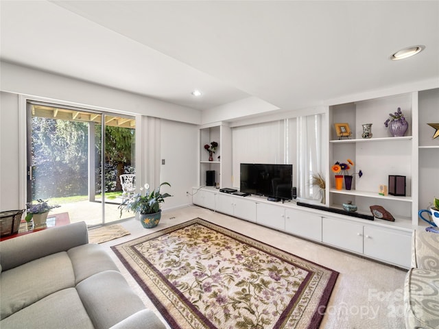 carpeted living area with built in features and recessed lighting