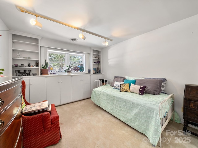 bedroom featuring visible vents, light carpet, and track lighting