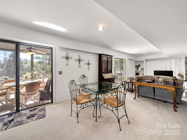 dining space featuring a healthy amount of sunlight and light carpet