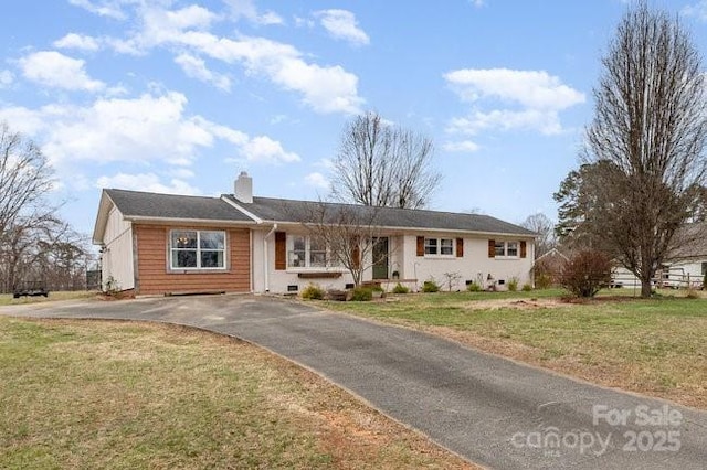 single story home featuring a chimney and a front lawn