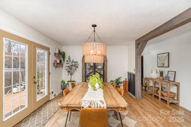 dining area featuring french doors, a notable chandelier, and light wood finished floors