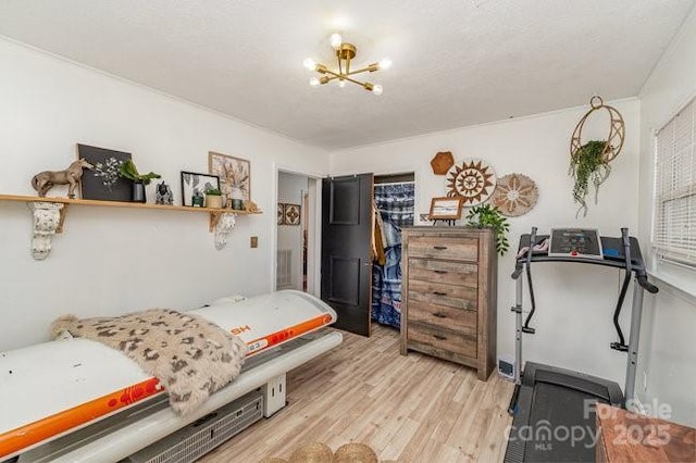 bedroom with light wood-type flooring and a notable chandelier