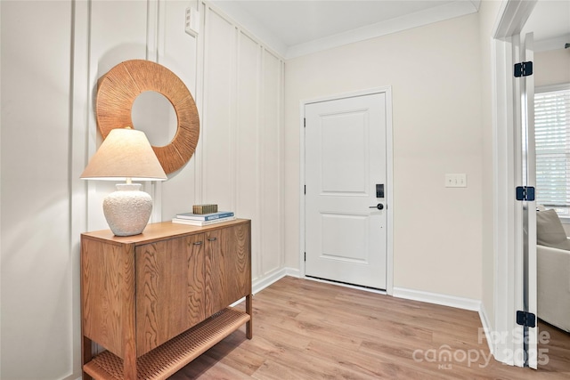 foyer entrance featuring light wood-style floors, ornamental molding, and baseboards