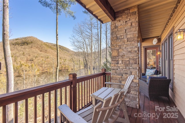 deck with a wooded view and a mountain view