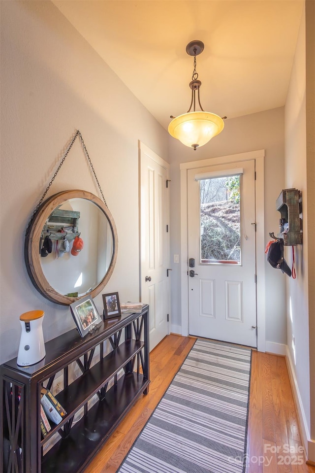 entryway with baseboards and light wood-style floors