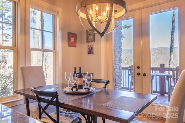 dining room with french doors, a notable chandelier, and a mountain view