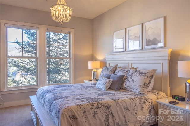 carpeted bedroom with baseboards and a notable chandelier