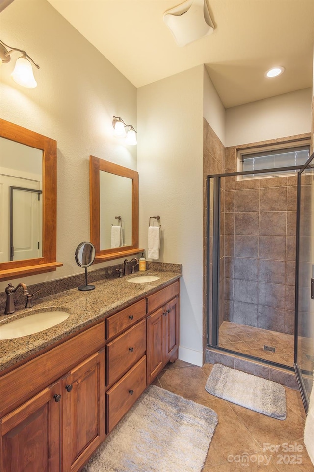 full bathroom featuring double vanity, a sink, and a shower stall