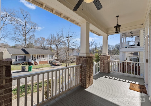 wooden deck featuring covered porch, a residential view, and ceiling fan