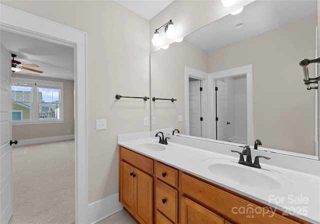 bathroom featuring double vanity, baseboards, and a sink