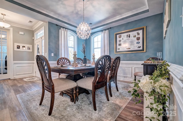 dining room featuring visible vents, wood finished floors, and wainscoting