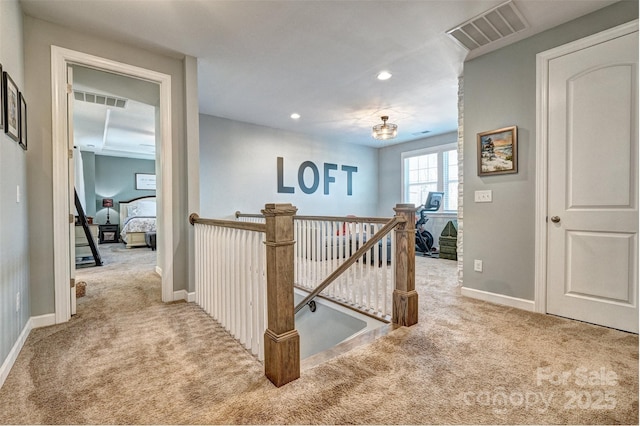 hallway with light carpet, baseboards, visible vents, an upstairs landing, and recessed lighting