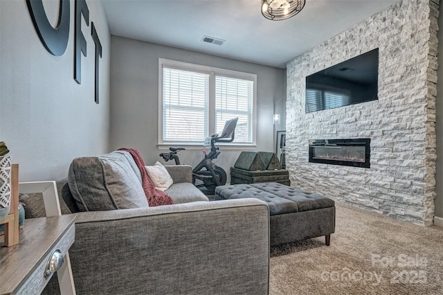 carpeted living room with visible vents and a fireplace