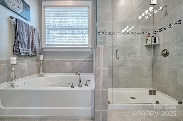 bathroom with a stall shower and a garden tub