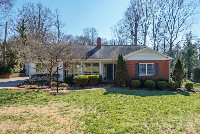 ranch-style house with driveway, brick siding, a front lawn, and an attached garage