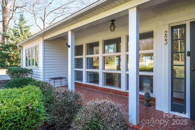 view of property exterior featuring covered porch and brick siding