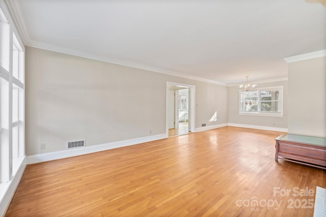 unfurnished living room with baseboards, visible vents, light wood-style flooring, crown molding, and a chandelier