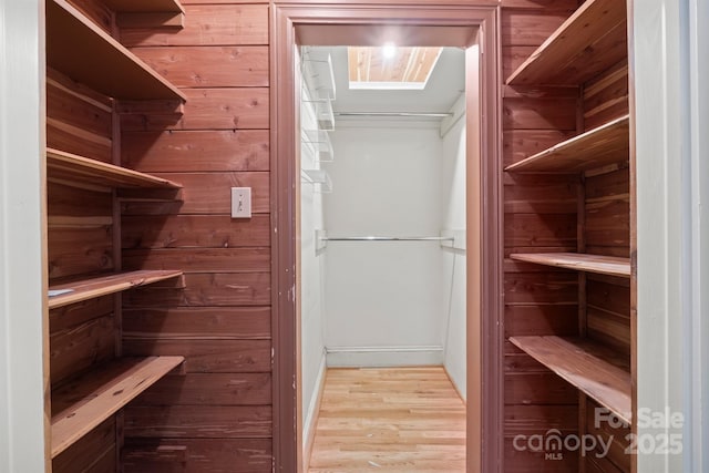 walk in closet with light wood-style flooring