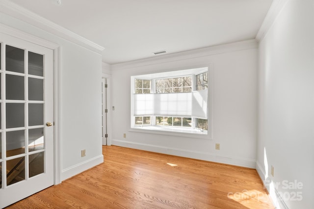 spare room with visible vents, crown molding, light wood-style flooring, and baseboards