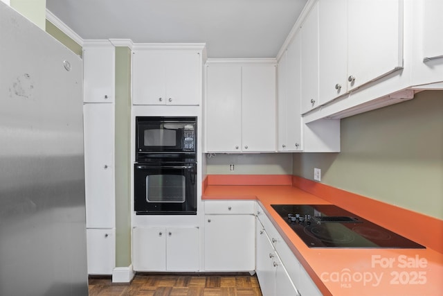 kitchen featuring white cabinetry, crown molding, and black appliances