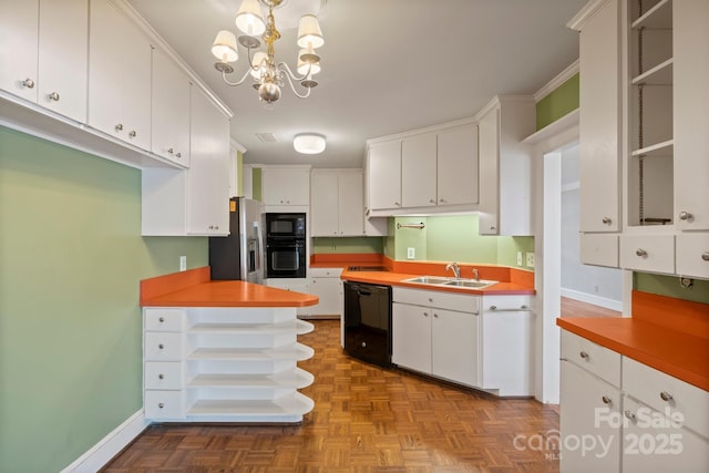 kitchen with a notable chandelier, white cabinetry, a sink, black appliances, and baseboards