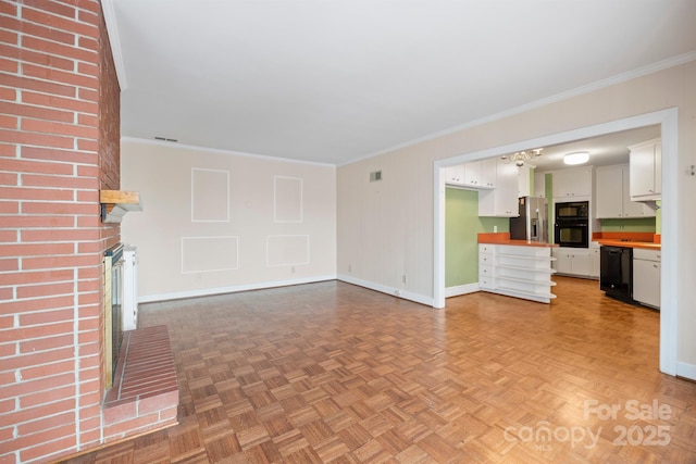 unfurnished living room featuring baseboards, a brick fireplace, visible vents, and crown molding