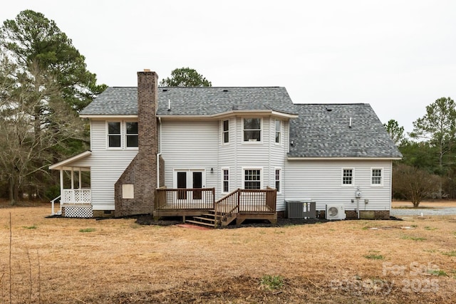 back of property with roof with shingles, ac unit, a chimney, a yard, and crawl space