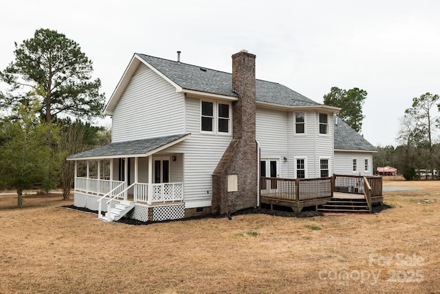 rear view of property with a porch, a yard, a shingled roof, a chimney, and crawl space