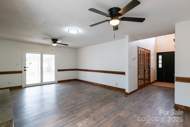 unfurnished room with ceiling fan, baseboards, a textured ceiling, and wood finished floors