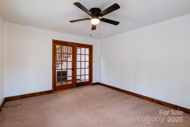 spare room featuring french doors, baseboards, and carpet