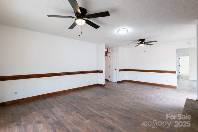 spare room featuring dark wood-type flooring, baseboards, and a textured ceiling