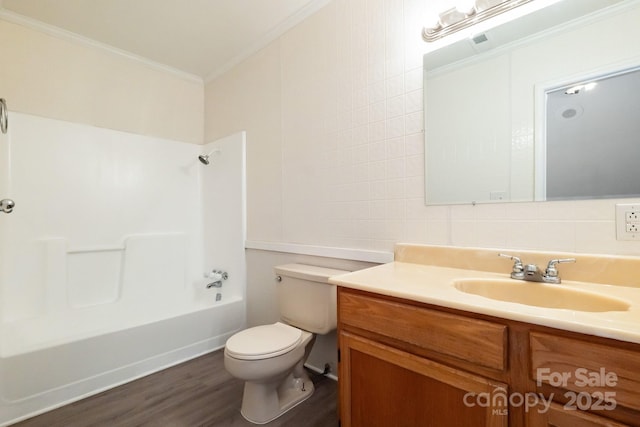 bathroom featuring vanity, wood finished floors, ornamental molding, bathing tub / shower combination, and toilet