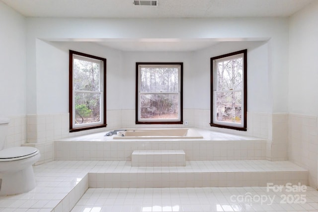 full bathroom featuring a bath, visible vents, and toilet