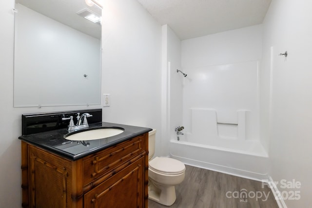 full bath featuring toilet,  shower combination, wood finished floors, and vanity