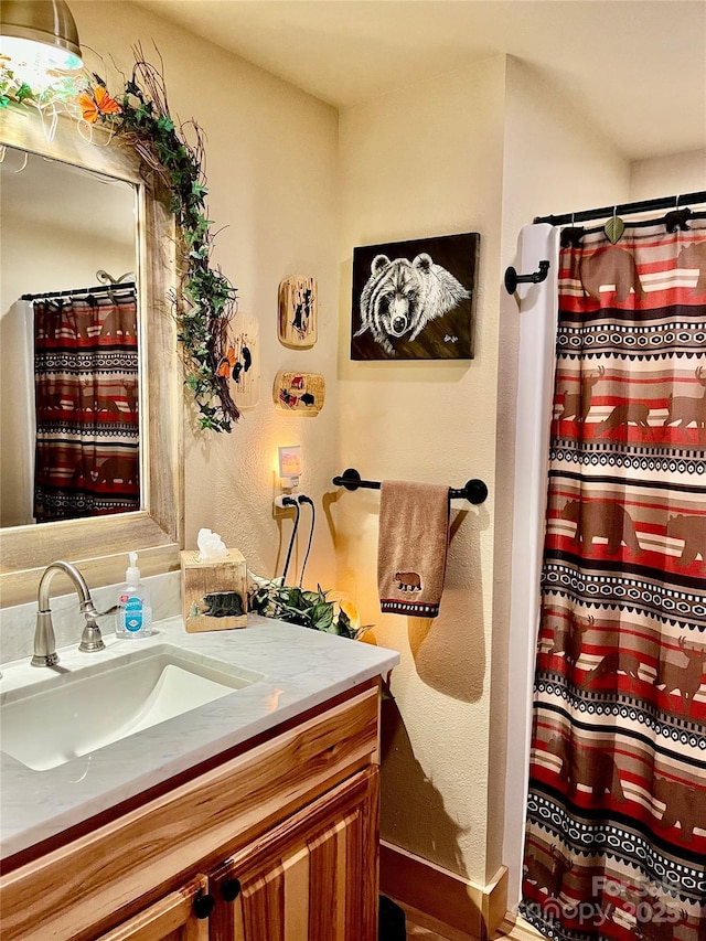 full bath featuring a shower with curtain, baseboards, and vanity